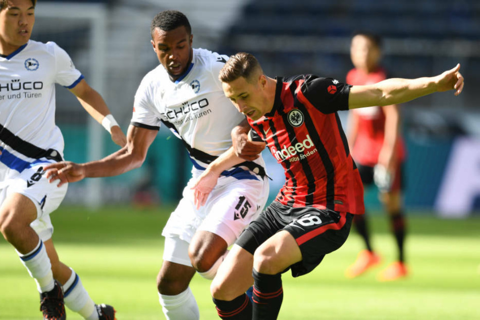 Eintracht Frankfurts Dominik Kohr (r.) im Zweikampf mit Nathan de Medina (M.) von Arminia Bielefeld.