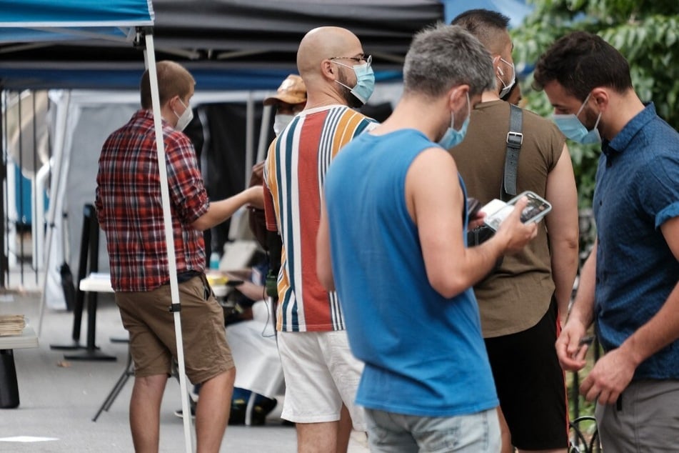 People line up to speak with healthcare workers with health care workers at intake tents where individuals are registered to receive the monkeypox vaccine in New York City.