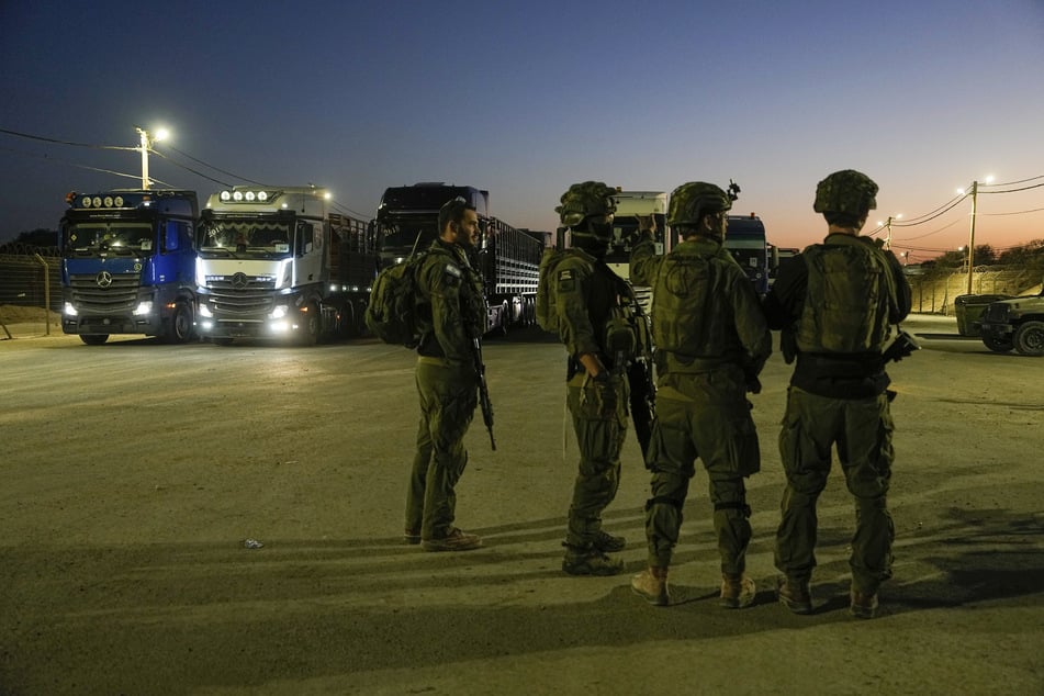 Israelische Soldaten stehen am Grenzübergang Erez im Süden Israels neben Lastwagen, die humanitäre Hilfe in den Gazastreifen transportieren sollen.