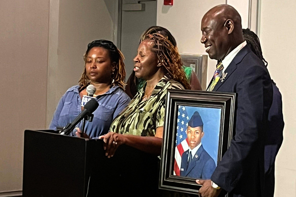 The mother of Senior Airman Roger Fortson (c.) speaks about the police killing of her son alongside attorney Ben Crump (r.).