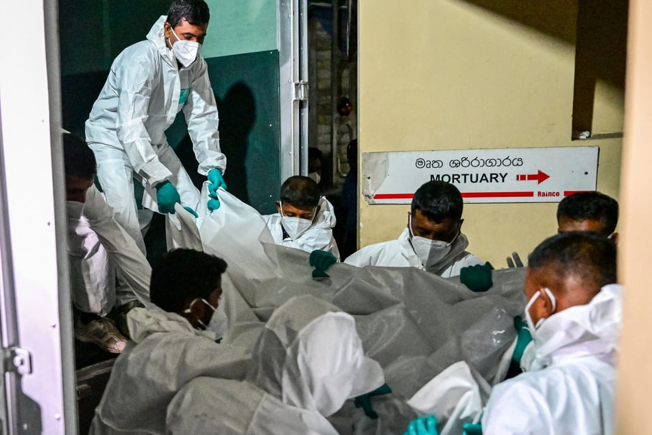 Healthcare workers carry the bodies of Iranian sailors killed in the US torpedo attack on their frigate IRIS Dena on Wednesday.