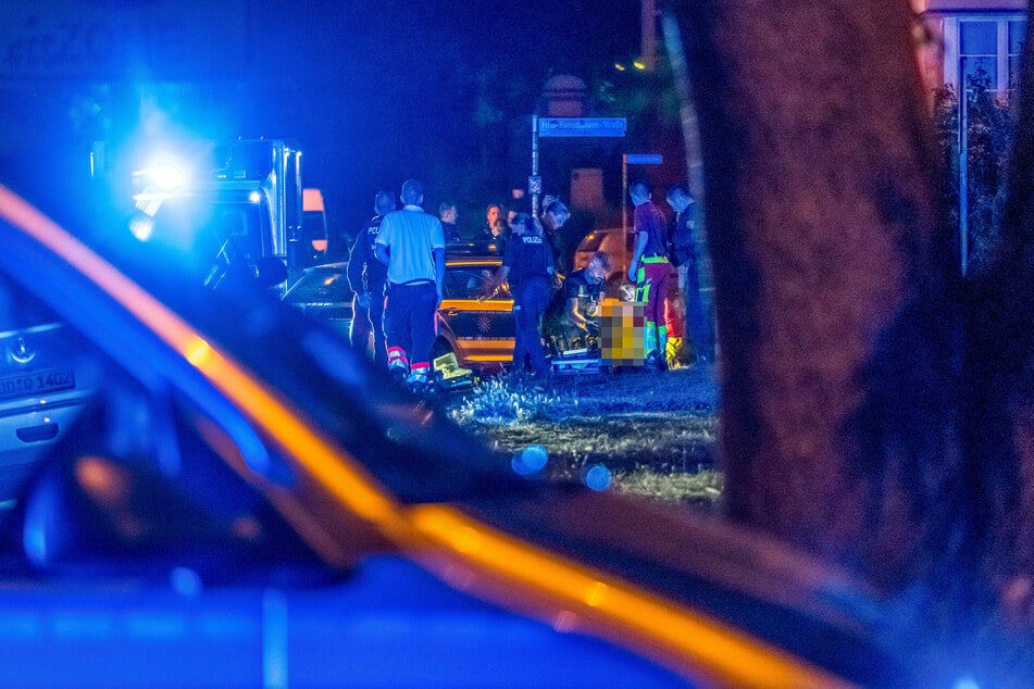 Polizisten und Sanitäter kümmern sich vor dem Haus um den lebensgefährlich verletzten Jungen.