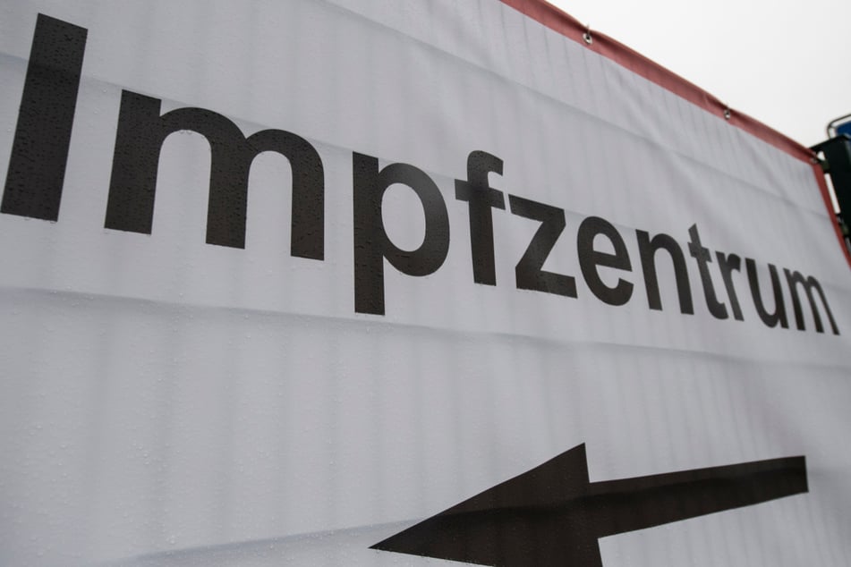 Ein Hinweisschild weist den Weg zu einem Impfzentrum.