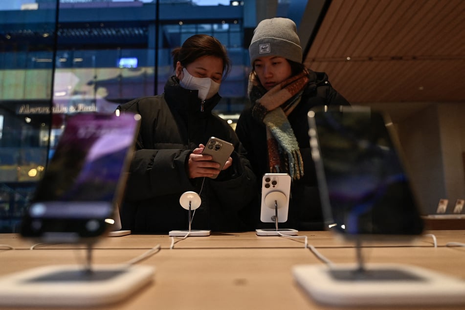 Women test an iPhone 16 in an Apple store in Beijing on February 13, 2025.