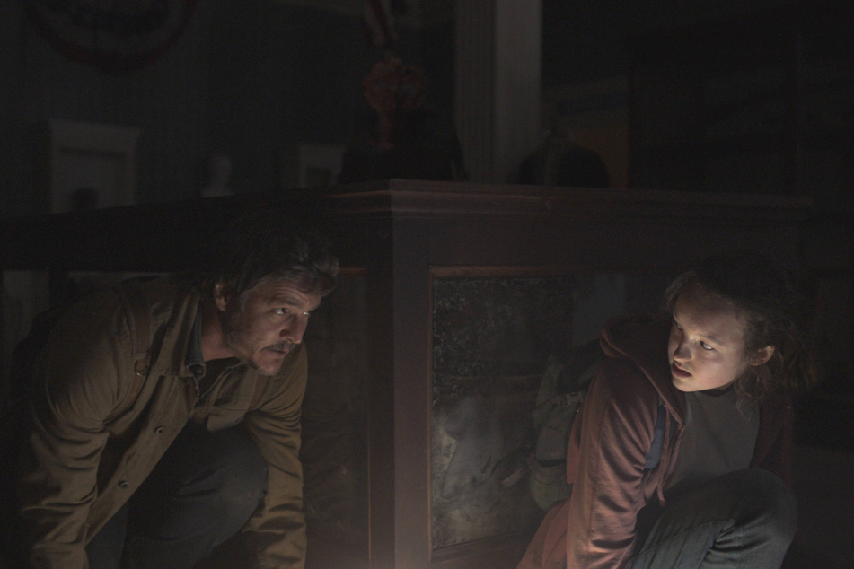 Joel, played by Pedro Pascal (l.), and Ellie hide from a Clicker in the second episode, Infected.