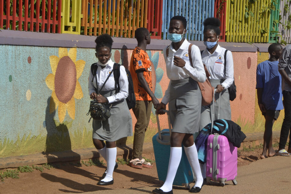 Schülerinnen verlassen ihre Schule in Ugandas Hauptstadt Kampala. Landesweit wurden Bildungseinrichtungen geschlossen, nachdem die Anzahl der Corona-Infektionen gestiegen ist.