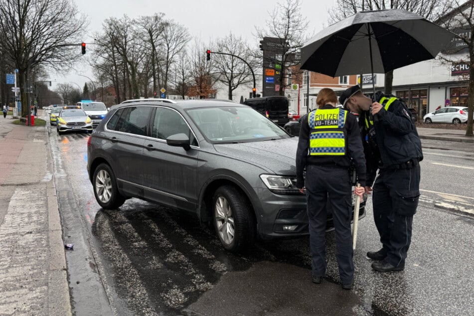 Beamte des Verkehrsunfalldienstes inspizieren den Wagen, der zuvor zwei Kinder in Hamburg erfasst hatte.