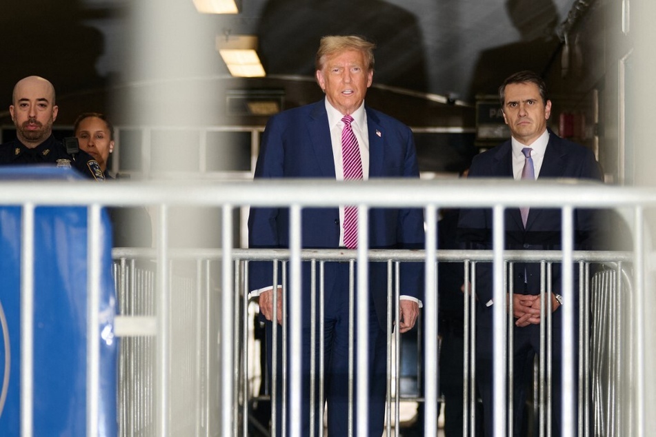 Donald Trump, flanked by lawyer Todd Blanche (r), speaks to the media after leaving the courtroom for the day during his trial for allegedly covering up hush money payments linked to extramarital affairs.