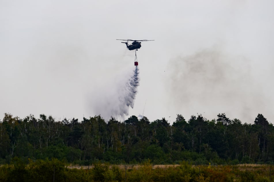 Löschhubschrauber der Bundeswehr und Feuerwehr sind im Waldbrand in der Gohrischheide im Einsatz.