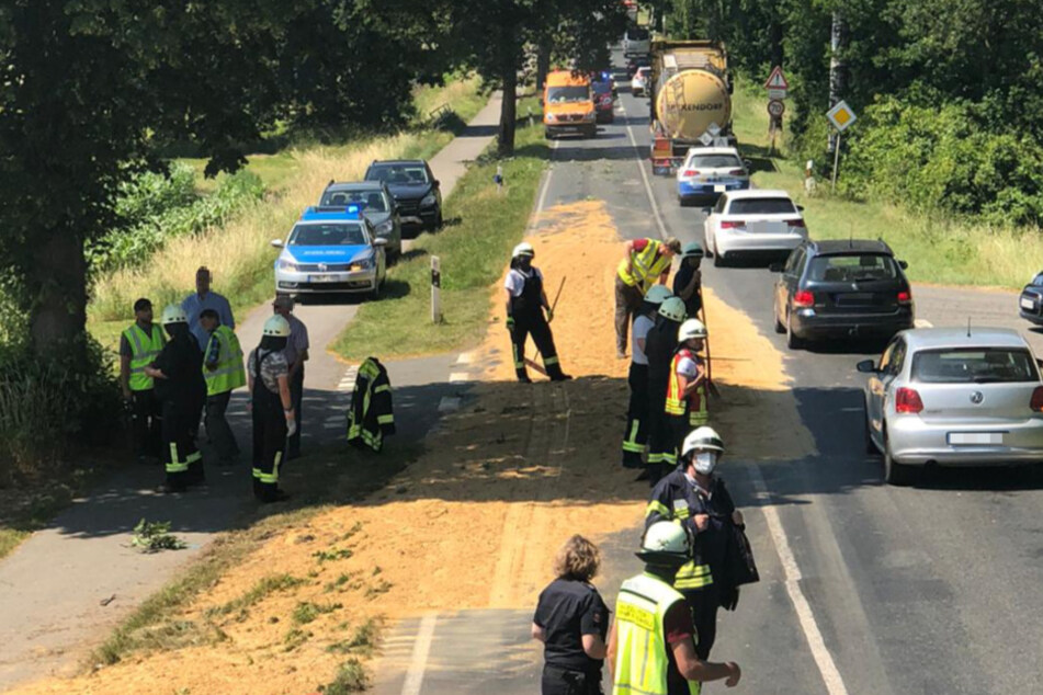Einsatzkräfte reinigen die Fahrbahn.