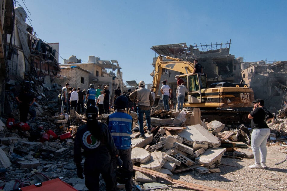 Civilians and rescue teams work together to clear the rubble and search for survivors after an Israeli airstrike near Rafik Hariri University Hospital in Beirut, Lebanon.