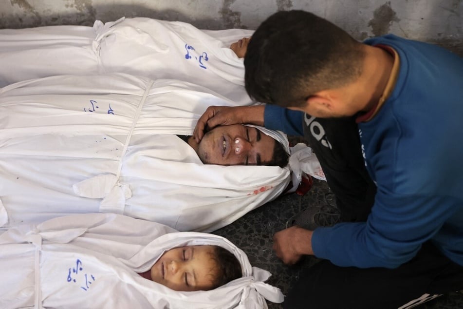 A Palestinian man mourns relatives, killed in an Israeli strike the previous night, at Al-Ahli Arab hospital, also known as the Baptist hospital, in Gaza City on January 1, 2025.