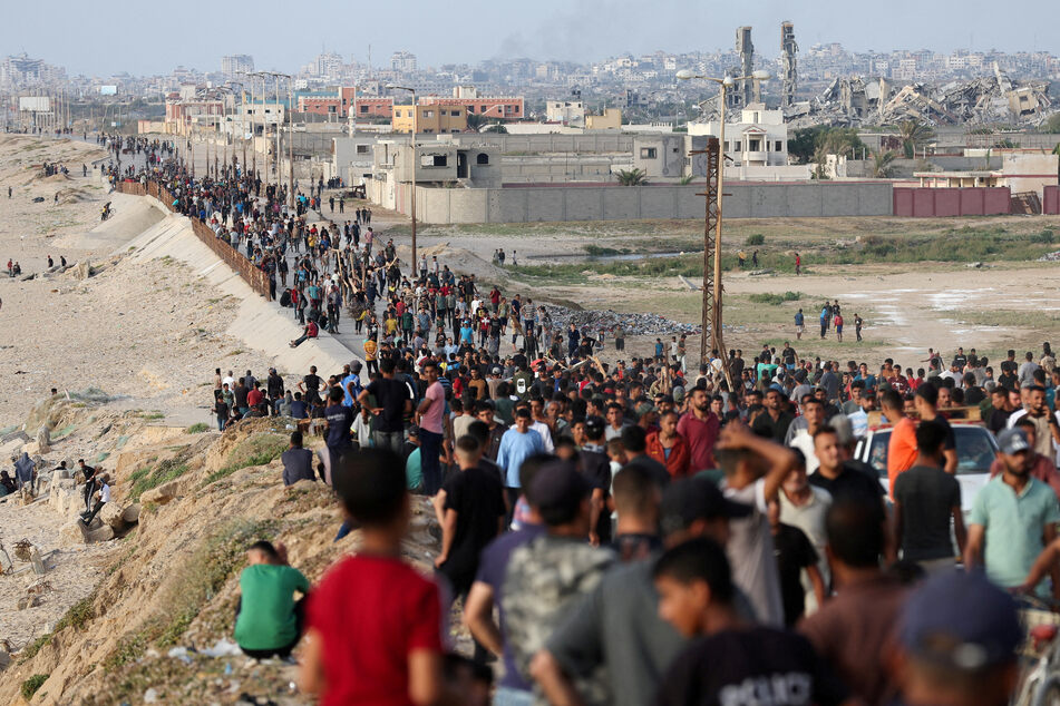 Palestinians gather in the hope of obtaining aid delivered into Gaza through a US-built pier.