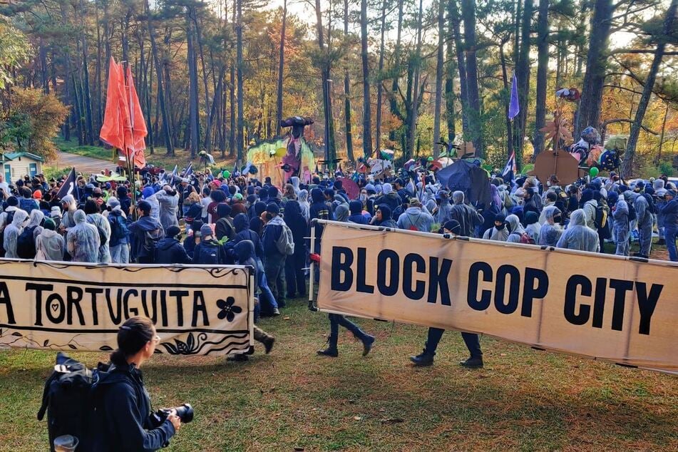 Stop Cop City activists rally and prepare to march against a planned $90-million militarized law enforcement training complex in Georgia's Weelaunee Forst.