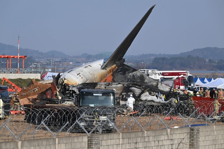 Firefighters and rescue personnel work near the wreckage of a Jeju Air Boeing 737-800 series aircraft after the plane crashed and burst into flames at Muan International Airport in South Jeolla Province on December 29, 2024.