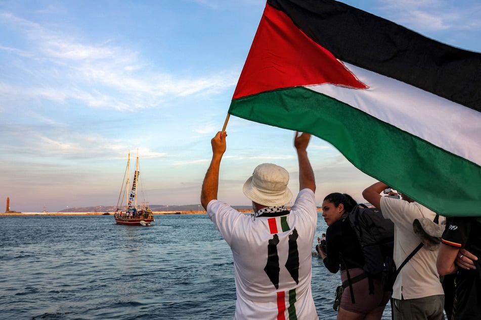 A man waves a Palestinian flag as a freedom flotilla vessel departs from Tunisia's northern port of Bizerte on September 14, 2025.