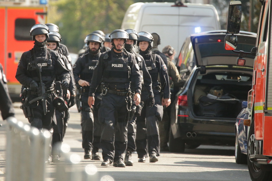 SEK-Polizisten, bewaffnet mit Maschinenpistolen, laufen über eine Straße. (Symbolbild)