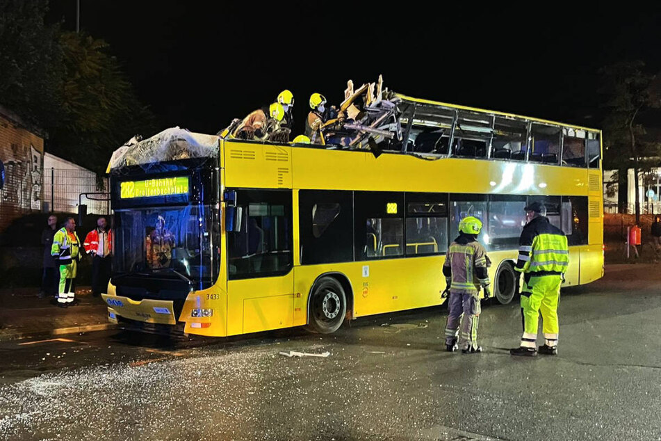 Feuerwehrleute begutachten den immensen Schaden am Oberdeck des BVG-Busses.