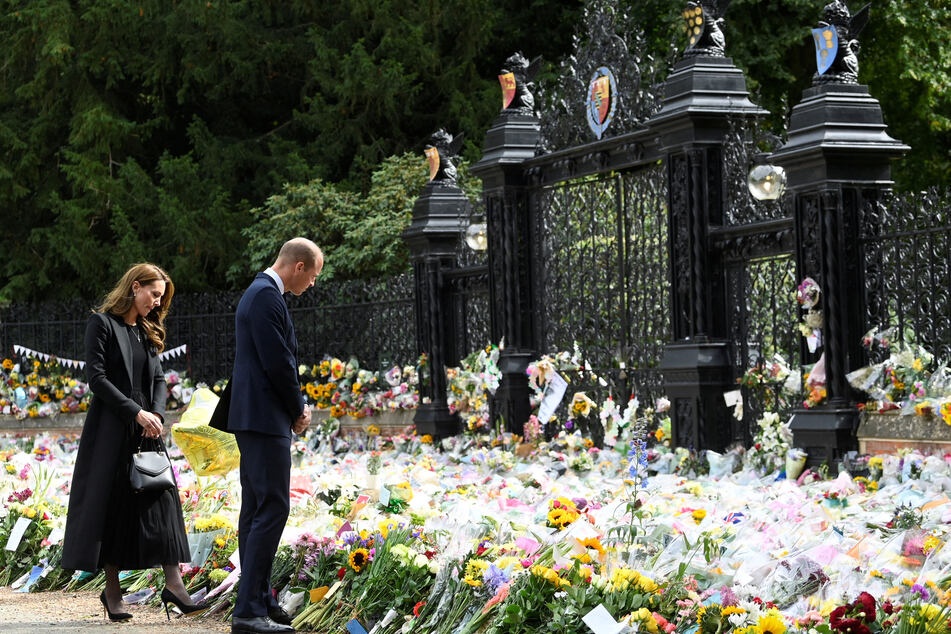 Prinz William (40, r.) und Prinzessin von Wales Kate (40) betrachten die Blumen, die vor den Toren von Sandringham House niedergelegt wurden.