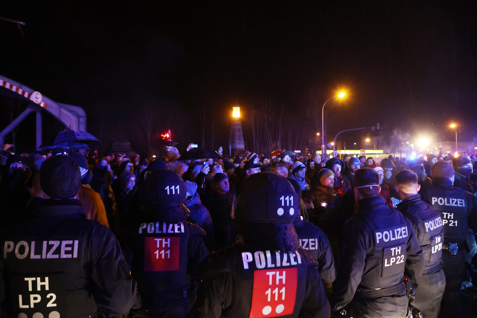 Polizeibeamte und Teilnehmer eines sogenannten Spazierganges gegen Corona-Maßnahmen stehen sich gegenüber. An der nicht genehmigten Demonstration in Greiz beteiligten sich mehrere hundert Menschen.