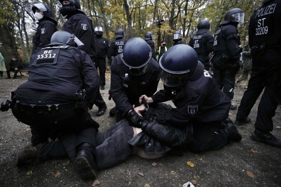 Polizisten legen einem Mann bei einer Demonstration gegen die Corona-Einschränkungen der Bundesregierung Handschellen an.