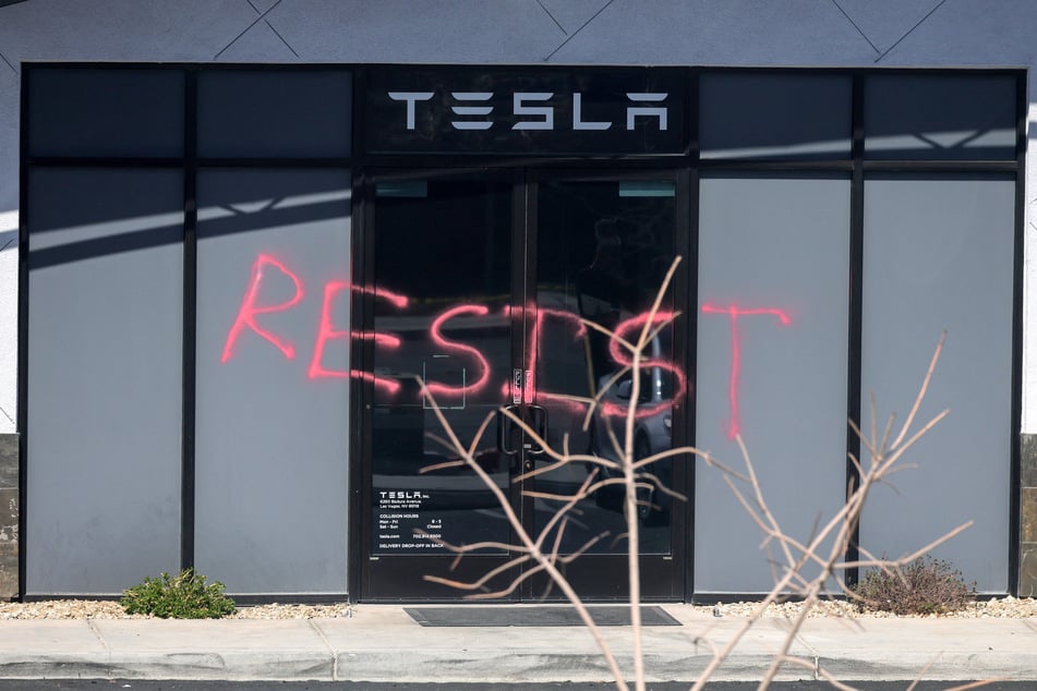 The word "RESIST" is spray painted on the entrance of a Tesla Collision Center after a person used incendiary devices to set several vehicles on fire on Tuesday in Las Vegas, Nevada.