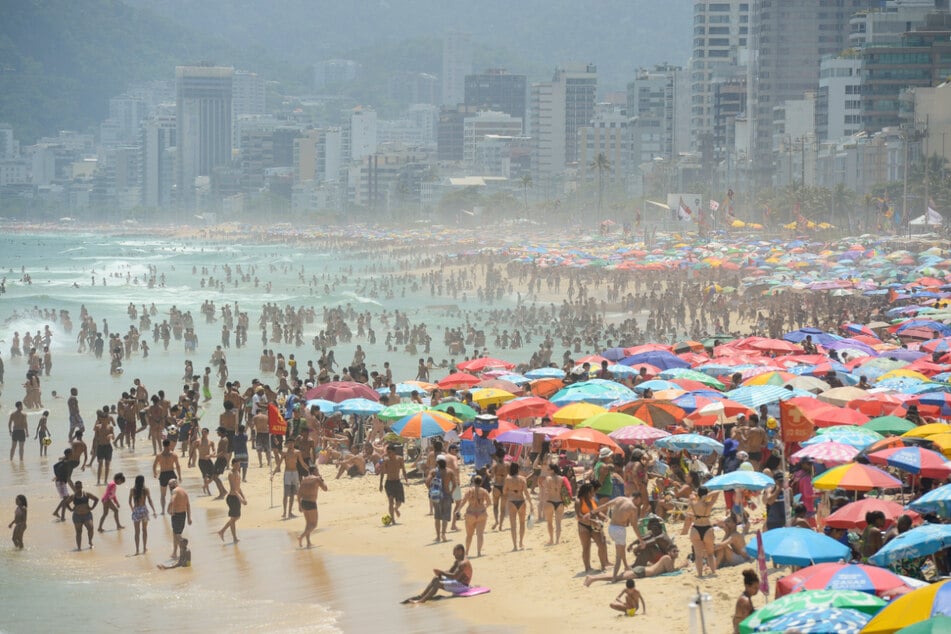 Zahlreiche Menschen suchen Erfrischung am Strand von Ipanema.