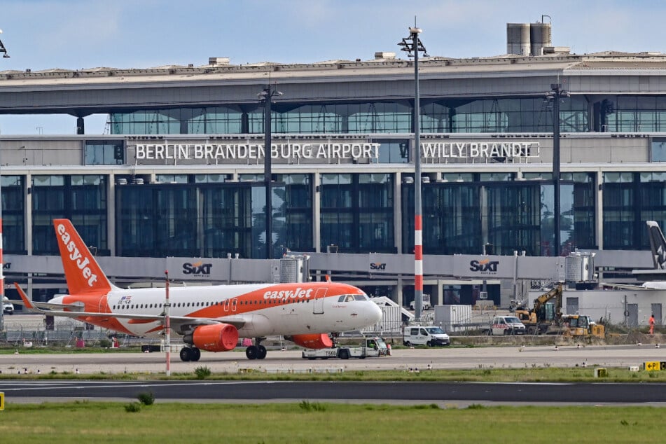 Ein Passagierflugzeug der britischen Fluggesellschaft Easyjet wird über das Vorfeld am Terminal 1 vom Hauptstadtflughafen Berlin Brandenburg "Willy Brandt" (BER) gezogen.