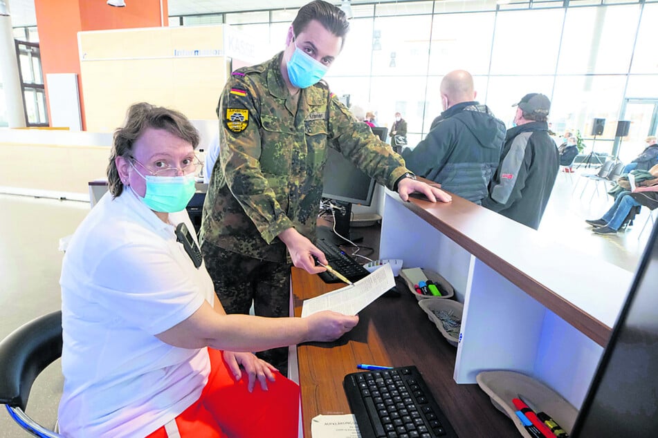 Oberfeldwebel Andrei Kramer (29) beim Schichtwechsel mit einer DRK-Mitarbeiterin.