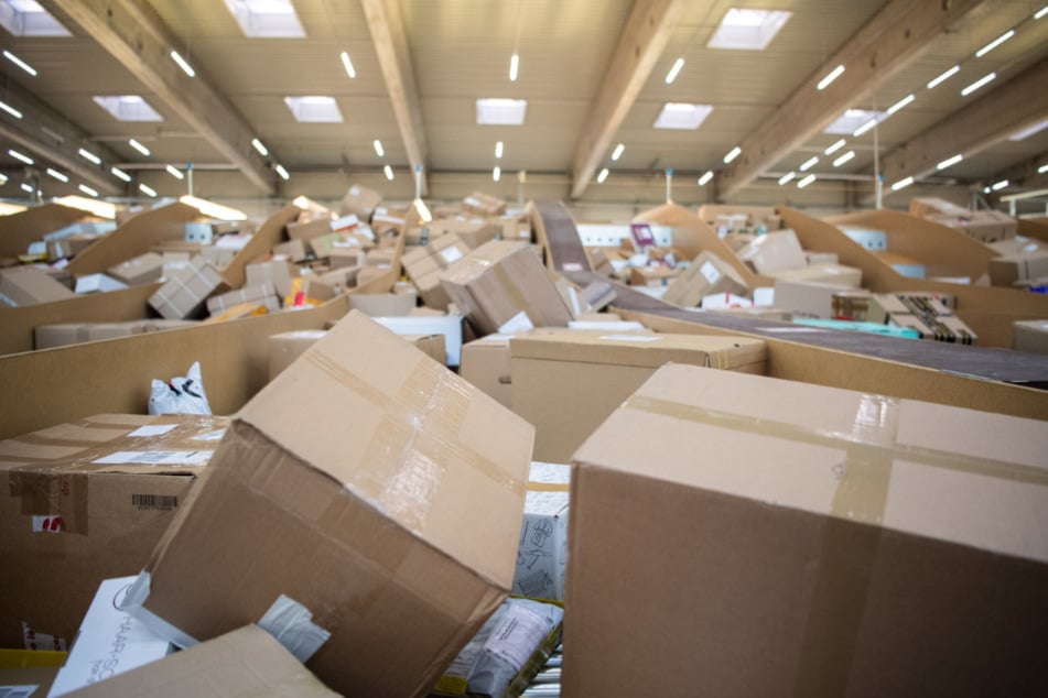 Pakete liegen in einem Paketzentrum von DHL.