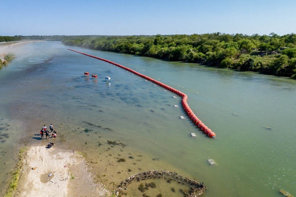 Migrants seeking asylum rest on an island while attempting to cross the Rio Grande river into the United States on July 18, 2023, in Eagle Pass, Texas.