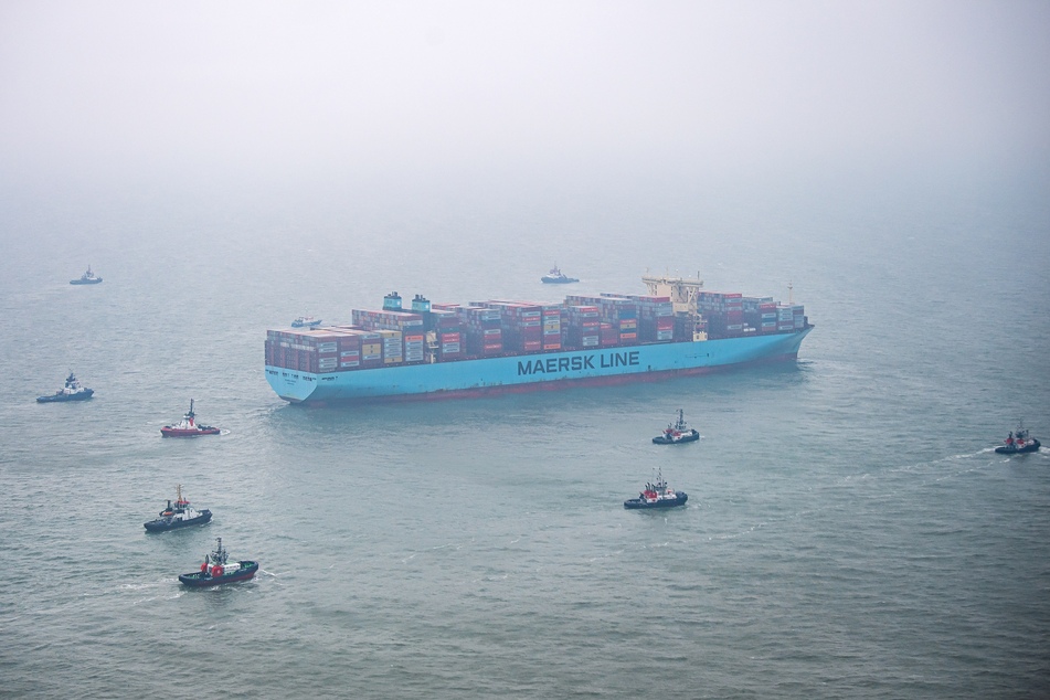 Das Containerschiff "Mumbai Maersk" liegt umringt von Schleppern in der Nordsee.