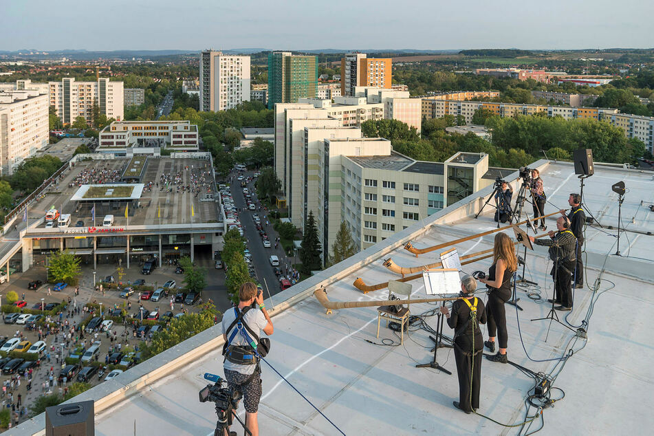 Vier Dresdner Sinfoniker mit ihren Alphörnern auf einem Hochhaus-Dach.