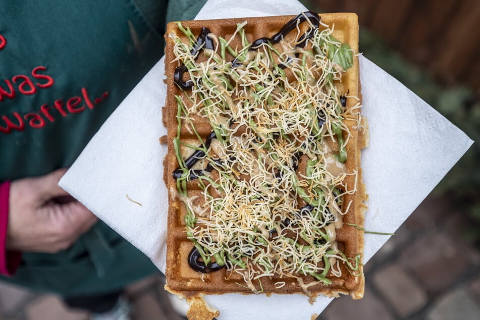 Die Waffel wird mit Schokoladensoße, Pistaziencreme, Sesampaste (Tahin) und "Engelshaar" belegt.