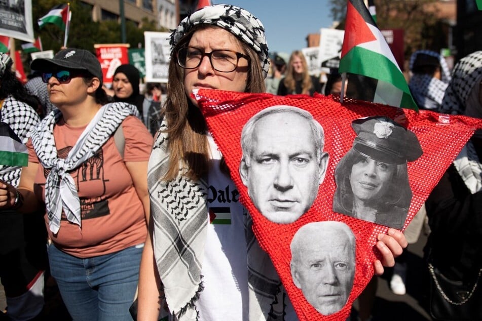 A protester holds a sign with images of Israeli Prime Minister Benjamin Netanyahu, US President Joe Biden, and US Vice President Kamala Harris as the Gaza genocide reached the one-year mark on October 7, 2024, in Denver, Colorado.