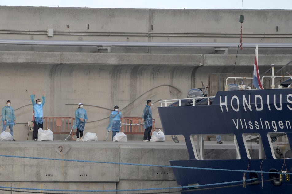 People with protective suits wait in line after disembarking from the hantavirus-stricken cruise ship MV Hondius docked in the port of Granadilla de Abona on the island of Tenerife in Spain's Canary Islands on May 11, 2026.