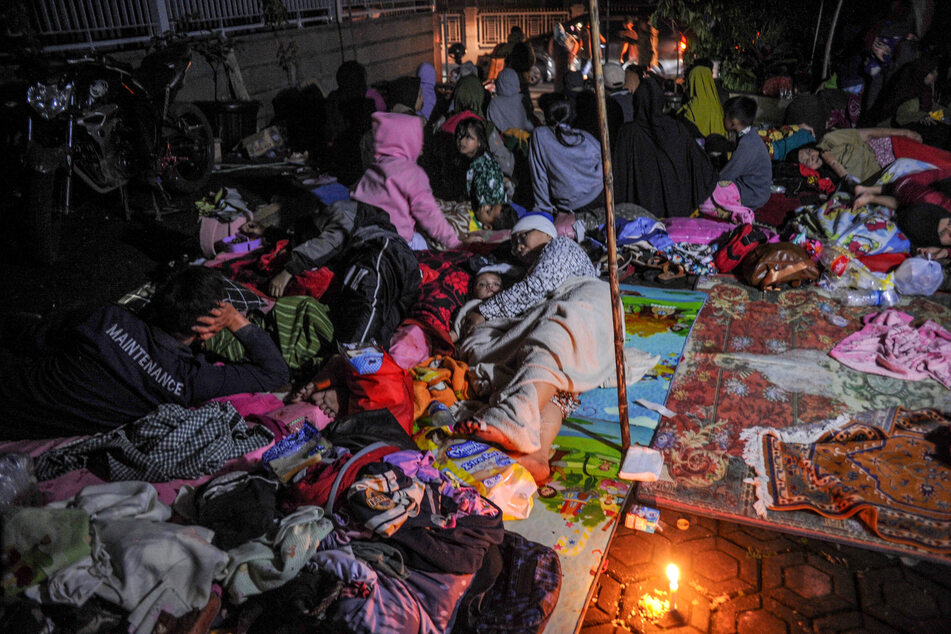 Displaced people shelter outside their destroyed houses on Monday night.