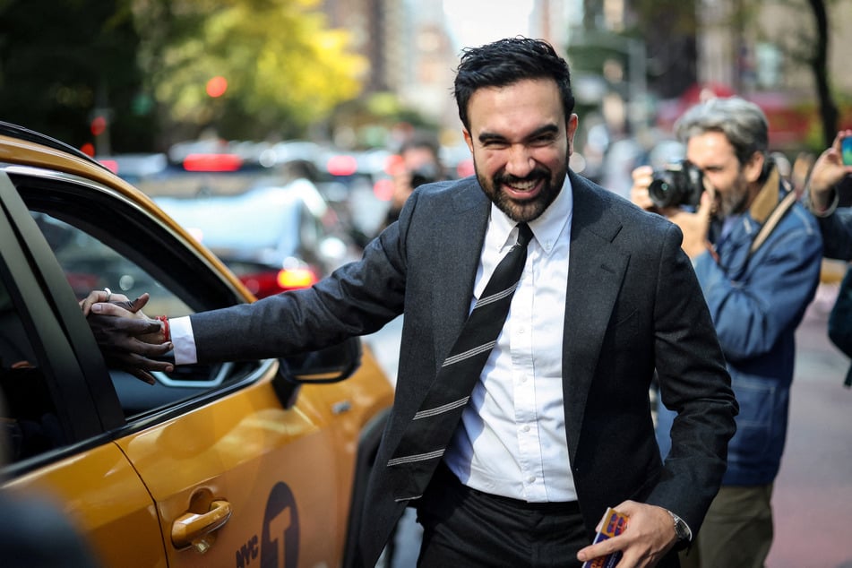 New York City moyoral candidate Zohran Mamdani shakes the hand of a cab driver while campaigning in Manhattan's Upper East Side during early voting on October 27, 2025.