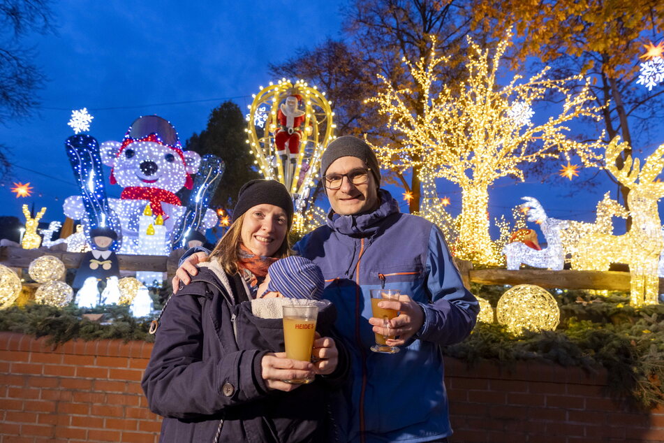 Doreen (35) genießt mit ihrem Mann Christian (36) und Sohn Florian (6 Monate) ein Heißgetränk vor dem weihnachtlich dekorierten Fährgarten Johannstadt.