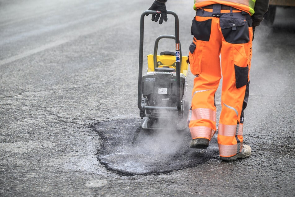In Chemnitz werden Schlaglöcher mit heißem Asphalt geschlossen, dieser dann festgerüttelt. Auch solche Aufträge sollen im Kartell verschoben worden sein.