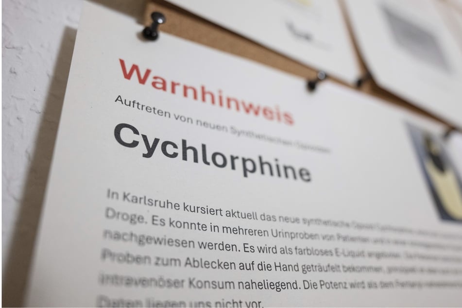 Ein Warnhinweis vor der synthetischen Droge Cychlorphine hängt in einem Drogenkonsumraum.