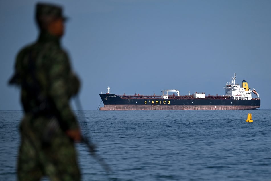 The High Challenge tanker ship, operated by d'Amico Shipping Group, sails as a Colombian soldier patrols the Pozos Colorados beach within the framework of the International Conference on the Just Transition Away from Fossil Fuels in Santa Marta on April 29, 2026.