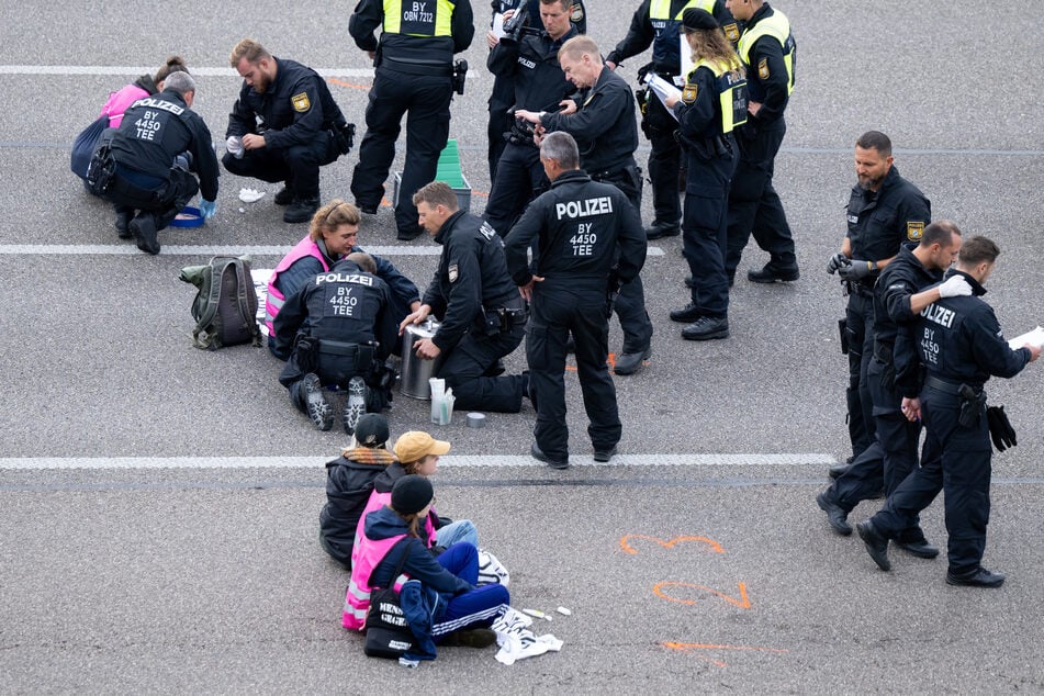 Speziell geschulte Kräfte lösten die festgeklebten Aktivisten von der Fahrbahn der A9 ab.