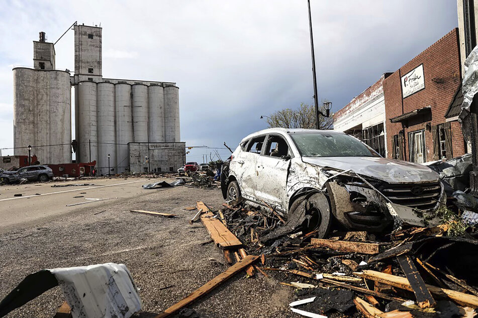 Ein beschädigtes Fahrzeug steht in Gebäudeteilen, die auf der Straße liegen.