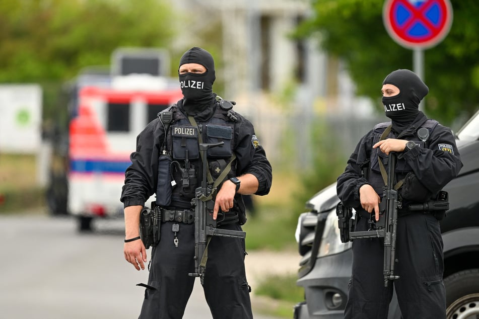 Schwer bewaffnete Beamte sperren im Industriepark Ost in Ludwigsfelde den Zugang zu der betroffenen Lagerhalle.