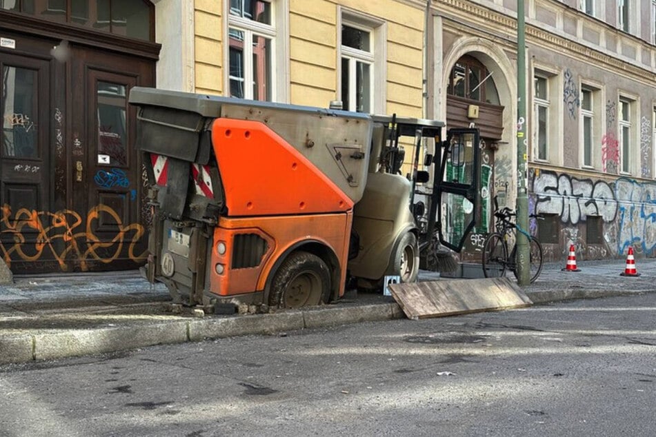 Die Kehrmaschine ist mit dem rechten Hinterrad in den Gehweg eingesackt.