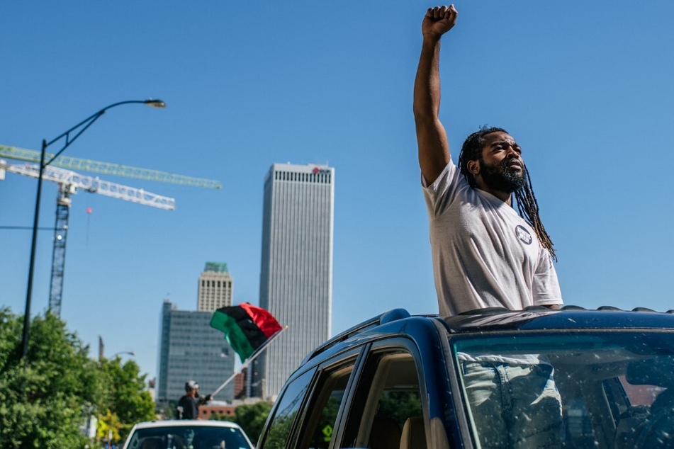 A man raises his fist in the air during a rally in the Greenwood district on the 100th anniversary of the Tulsa race massacre.