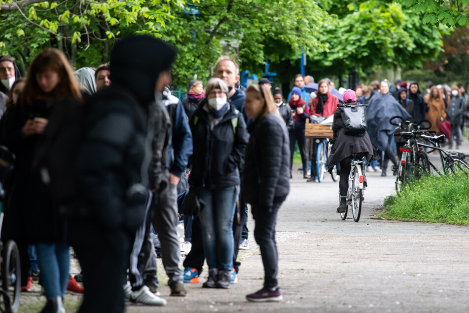 Zahlreiche Impfwillige warten auf den Gehwegen rund um eine Turnhalle einer Schule in Neukölln, wo eine Schwerpunktimpfung gegen Corona stattfindet.