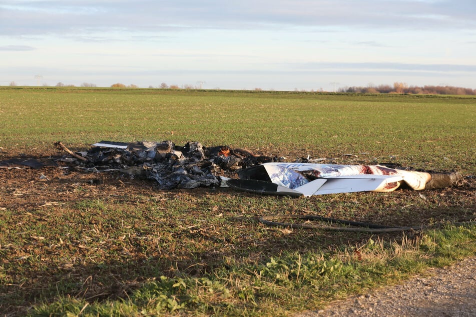 Ausgebrannte Überreste eines abgestürzten Kleinflugzeuges liegen an der Unfallstelle.