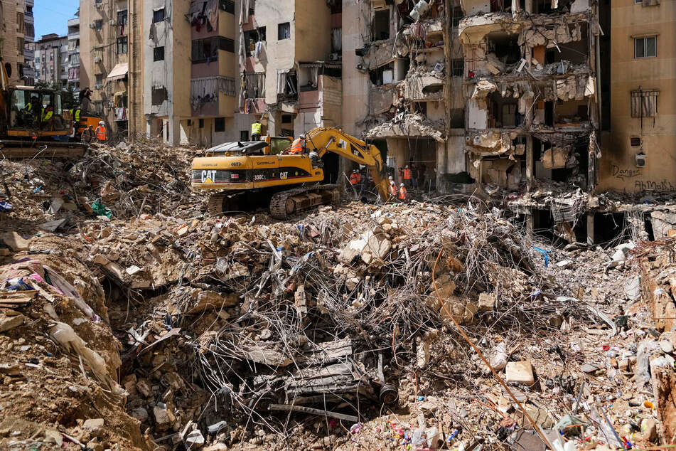 Rettungskräfte durchsuchen die Trümmer auf der Suche nach noch vermissten Personen am Ort des israelischen Angriffs vom Freitag in den südlichen Vororten.